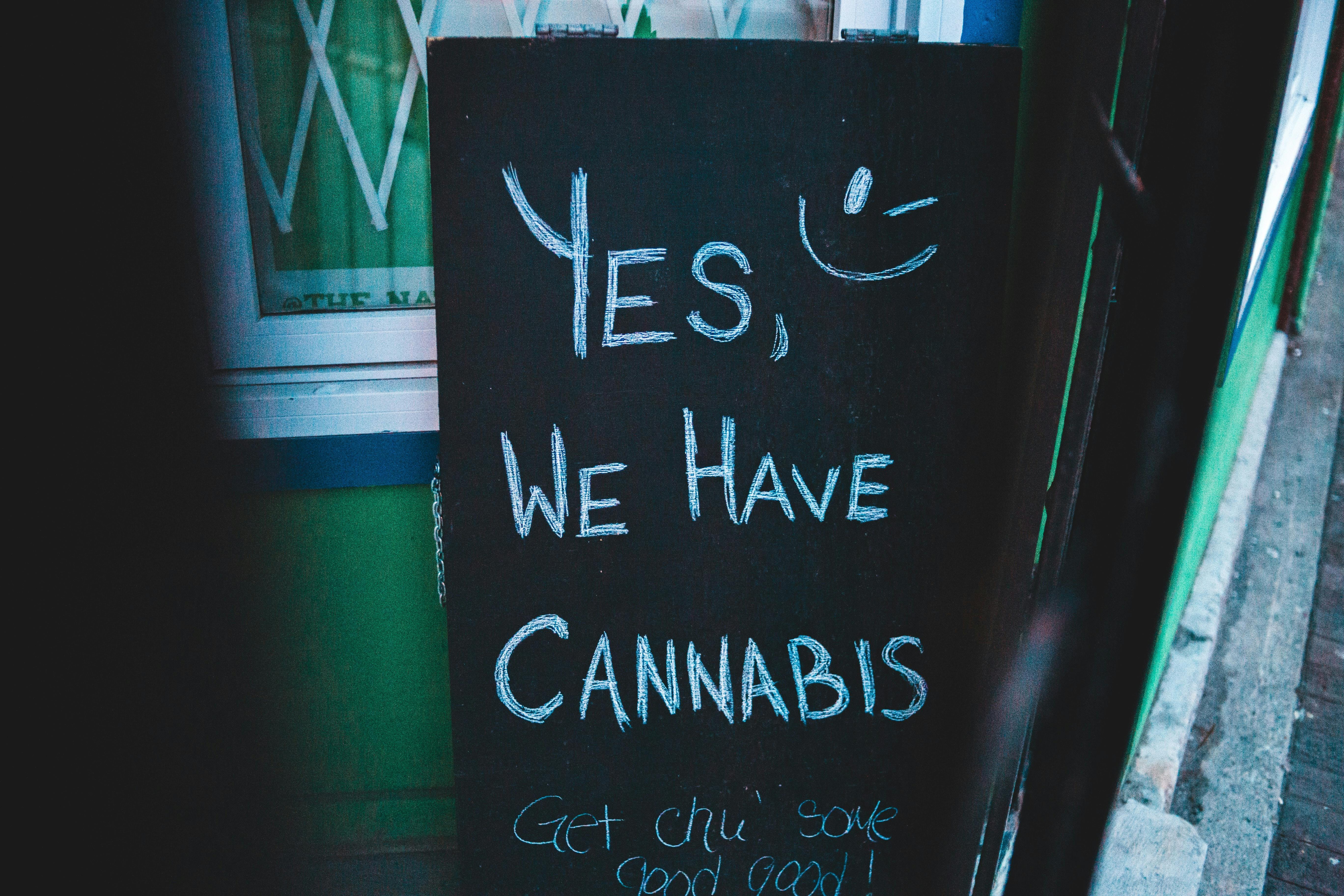 Sign outside of a shop that reads Yes, we have cannabis, next to a smiley face.